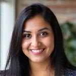 प्रिया शर्मा, एक ऊर्जावान ऑडियो निर्माता, विचारशील अभिव्यक्ति के साथ मुस्कुरा रही हैं.